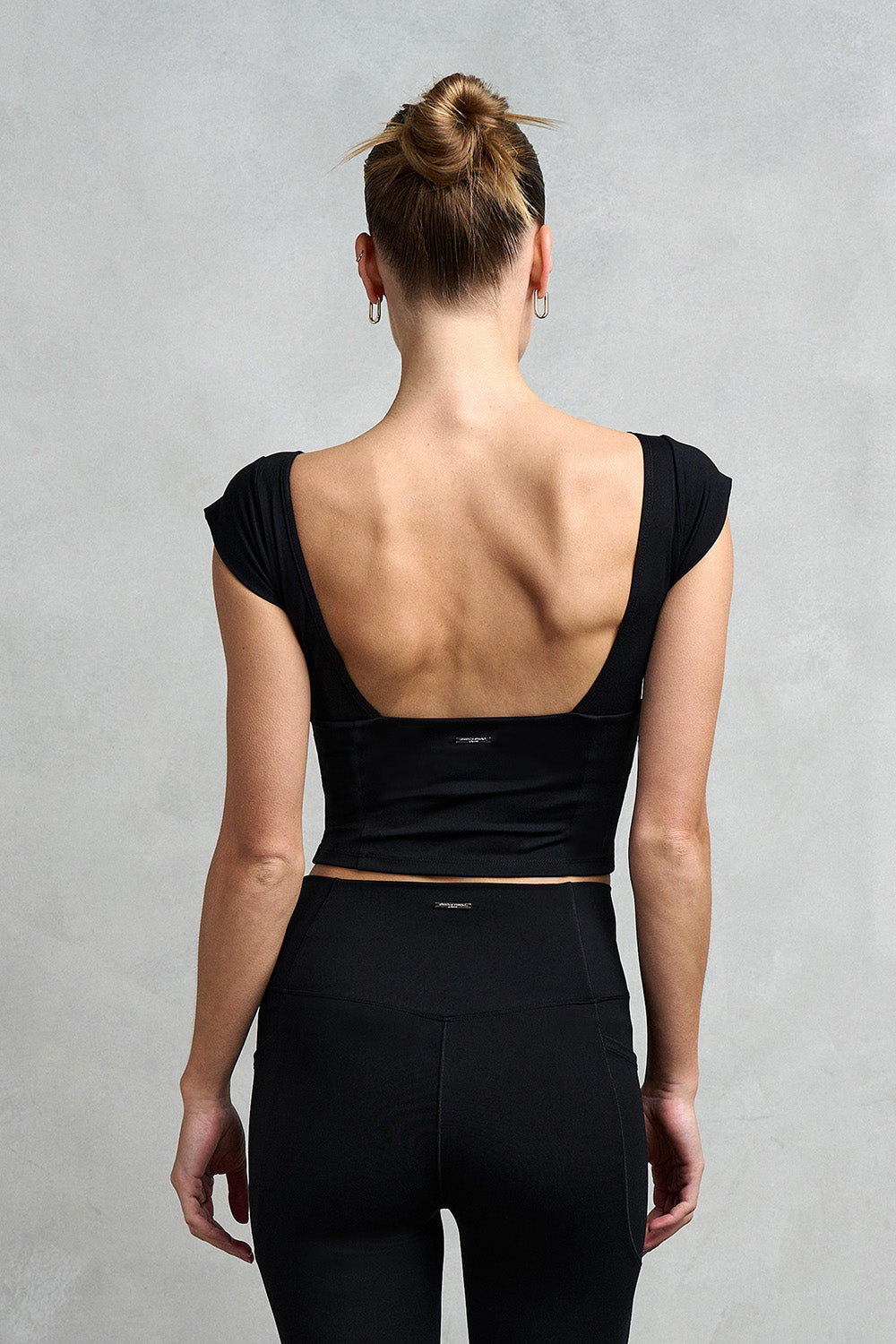 The back detail of the Camden Square Neck Backless Top. Featuring an elegant low scoop back that elevates any activewear look.