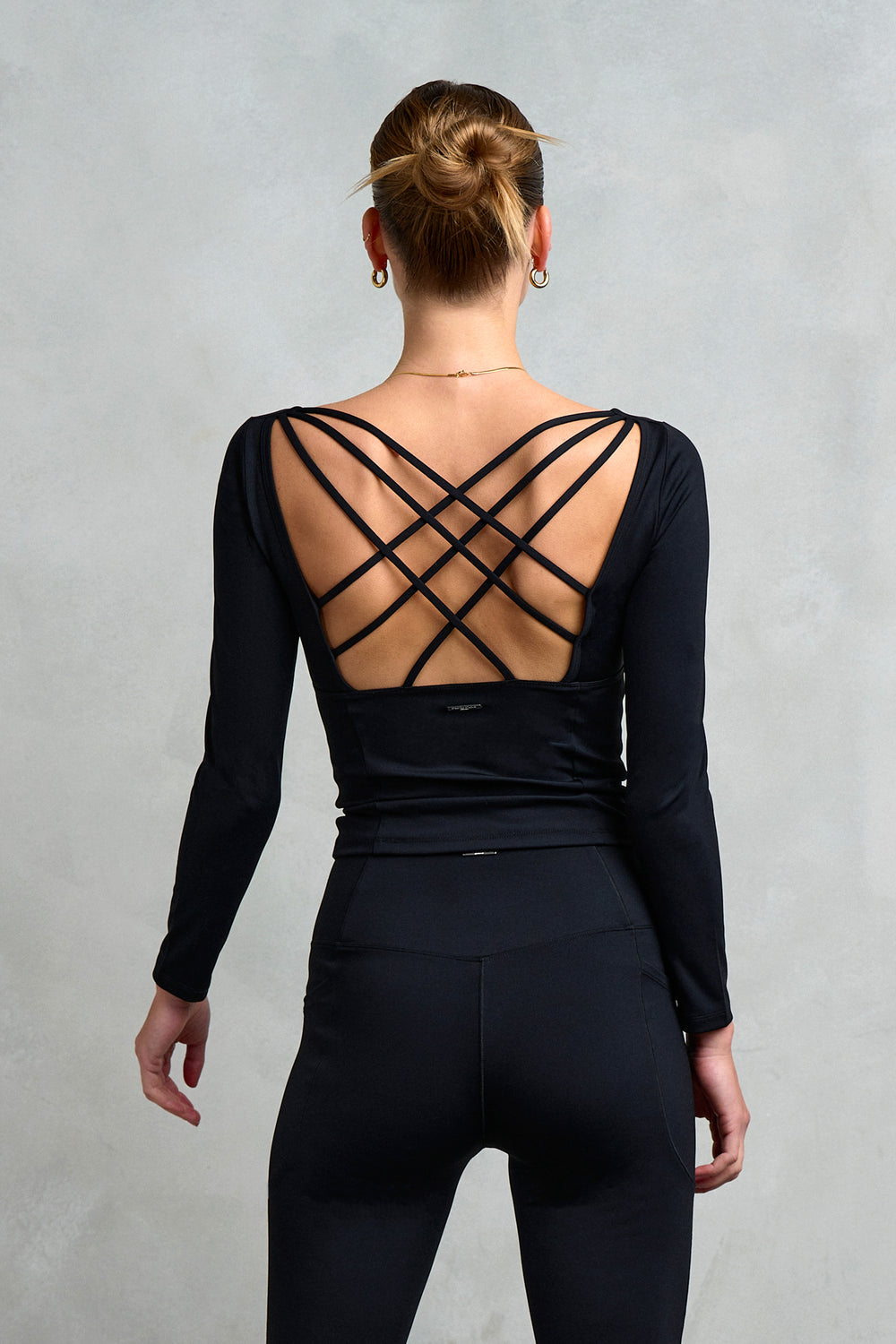 Back detailing of Stretch Studio London's Kensington Square Neck Cross Back Top, featuring long sleeves and a strappy cross back. 