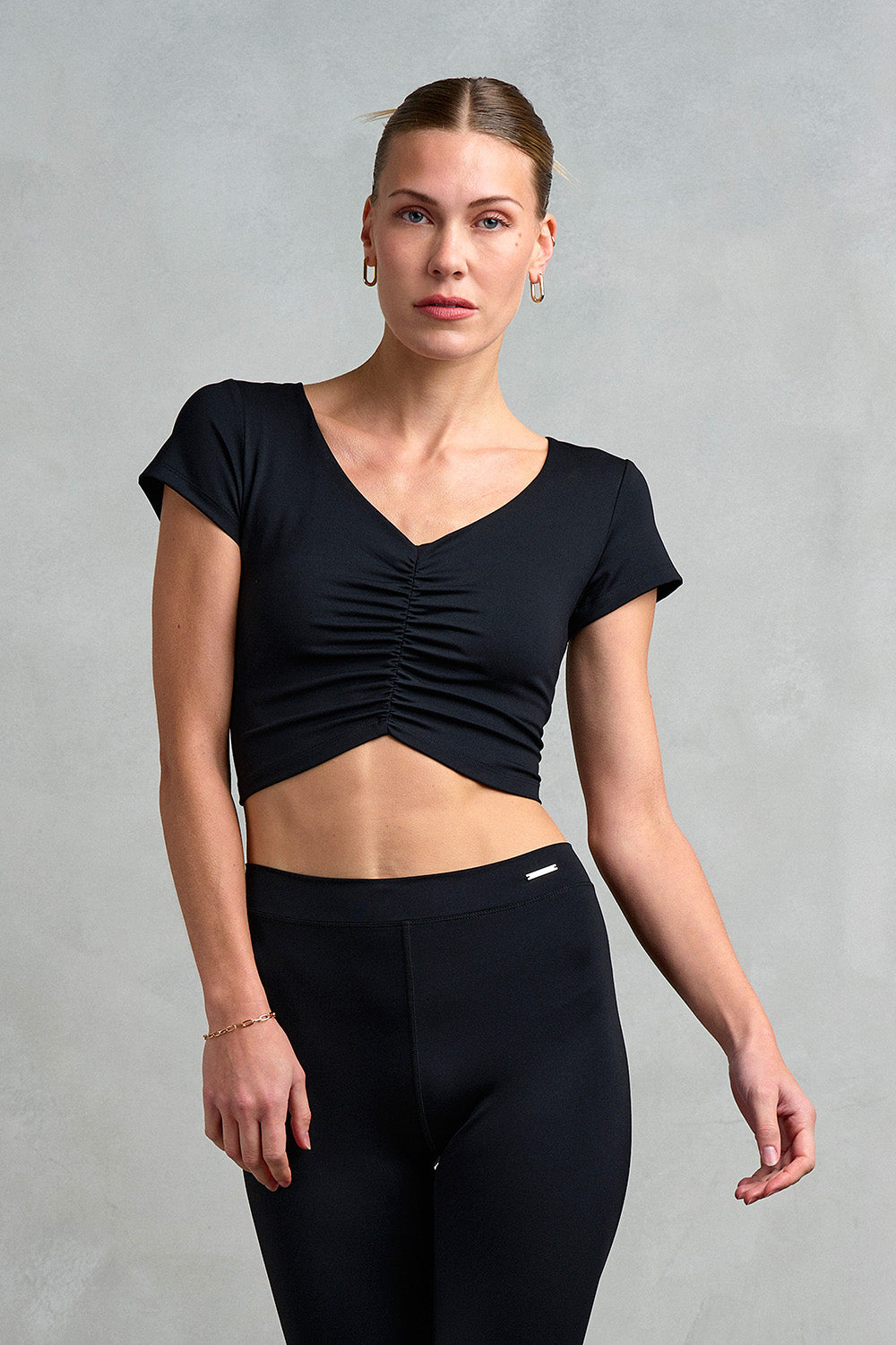 Luxury activewear from Stretch Studio London. Our model is wearing the Westminster Gathered Cap Sleeve Top with ruched front detail. 