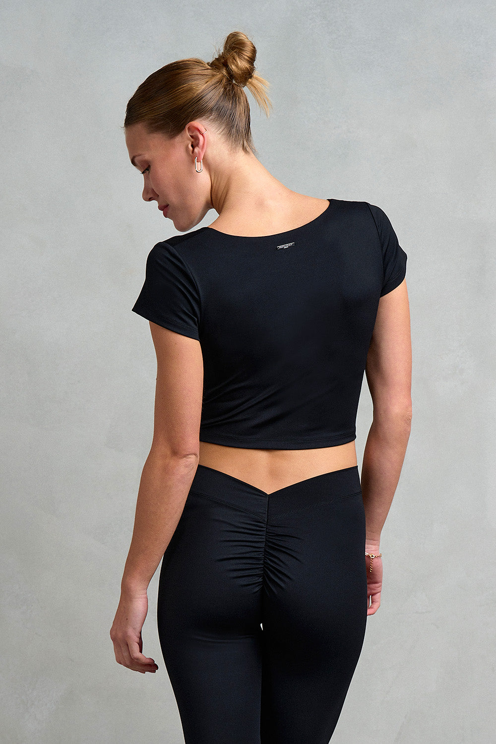 Back view of the Westminster Gathered Cap Sleeve Top from Stretch Studio London, featuring metal logo tab to back of neck. 